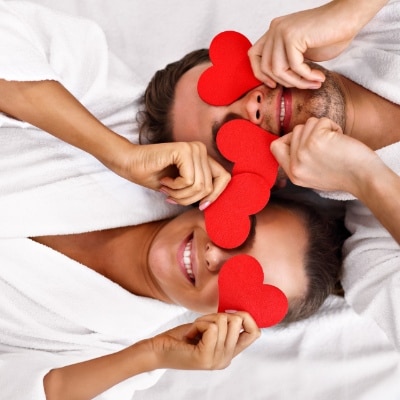 couple in robes with paper hearts over eyes sempre spa